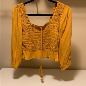 Yellow long sleeve cropped shirt.